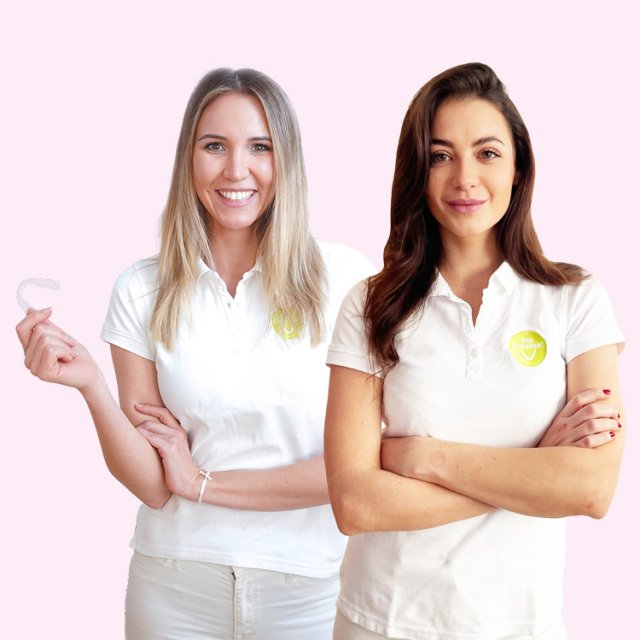 Two women from the SayCheeese team, one holding an aligner