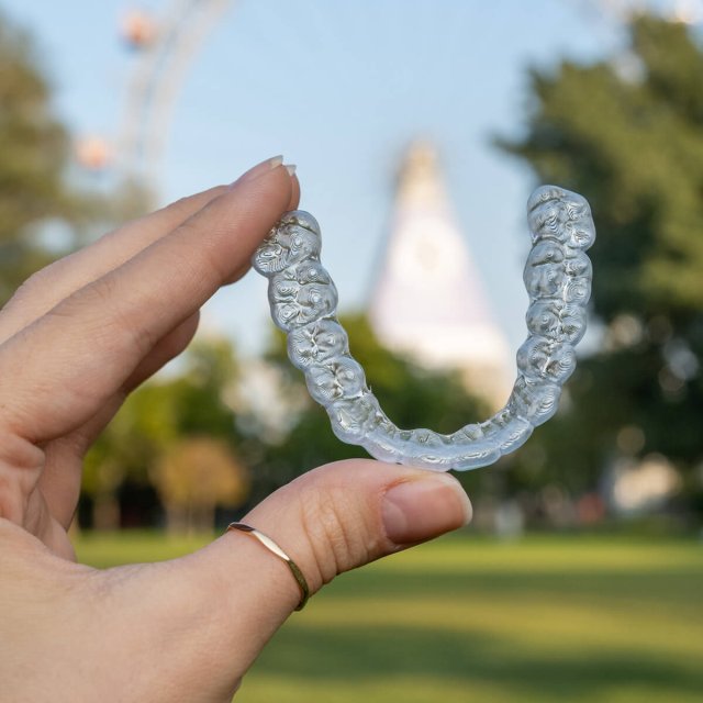 Zu den Vorteilen: Zahnschiene in der Hand vor dem Riesenrad