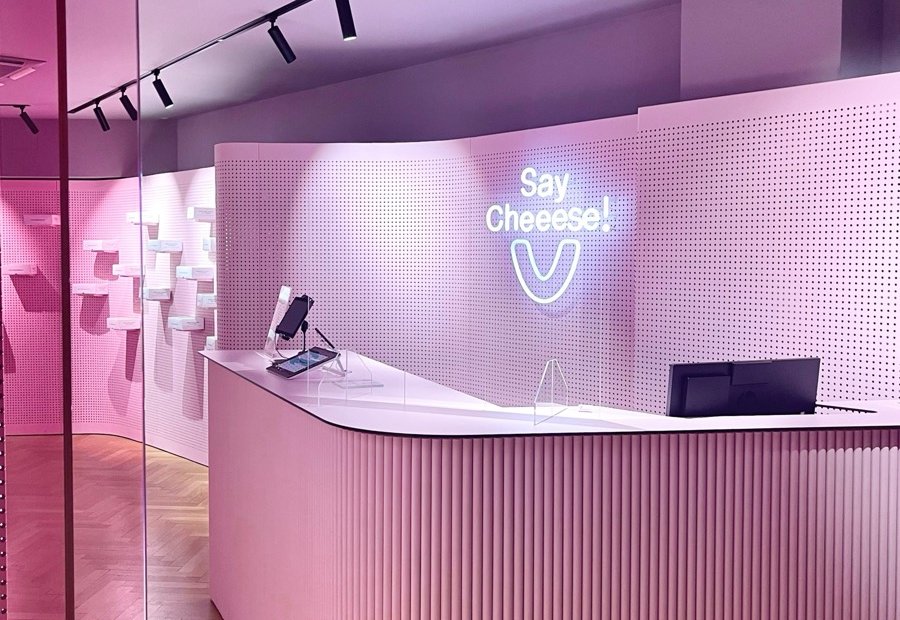 Pink reception area of the SayCheeese practice with a neon sign
